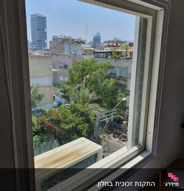 חלון זכוכית עם נוף עירוני ברקע